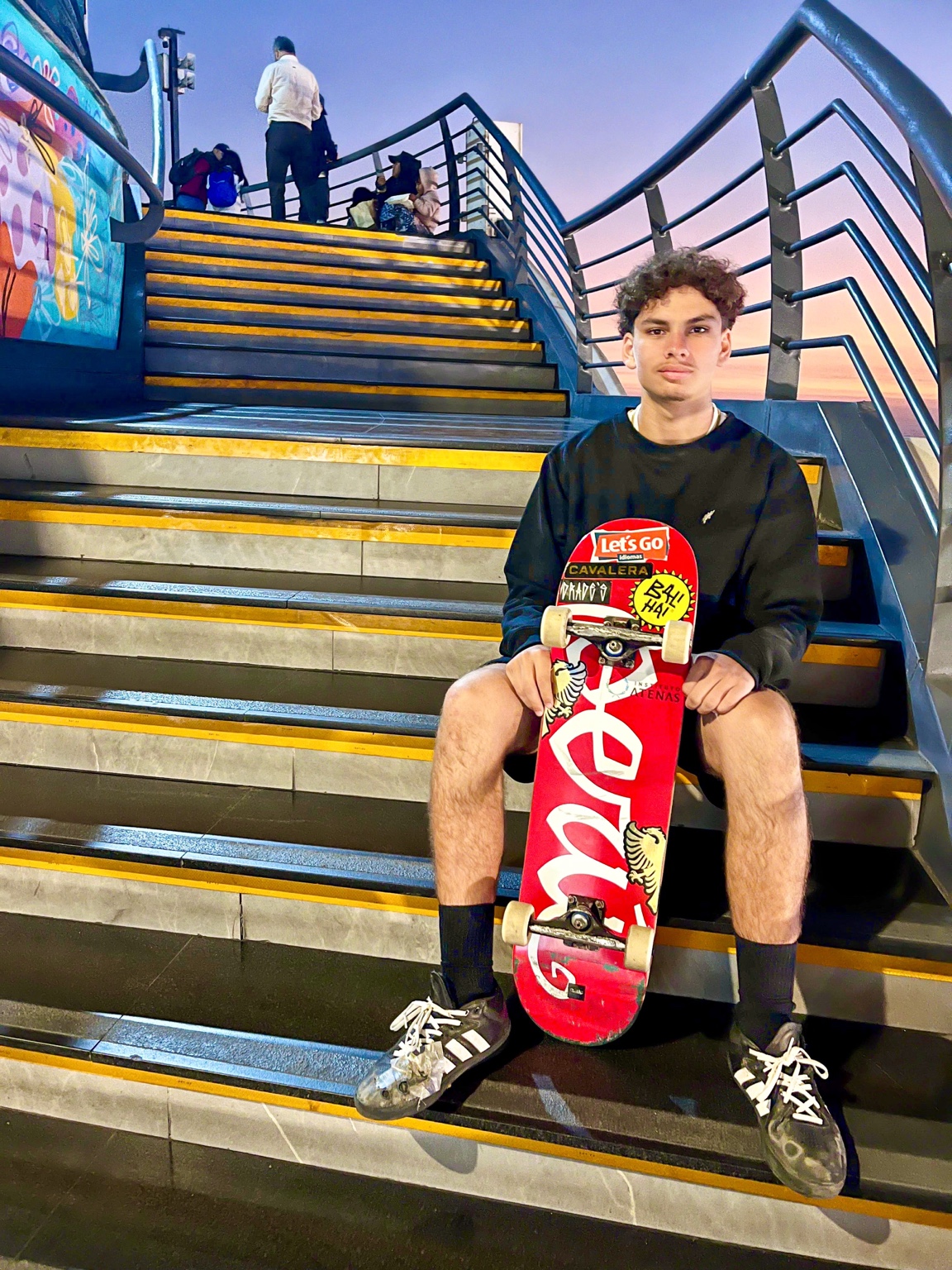 Pedro Gael sentado em uma escadaria com seu skate