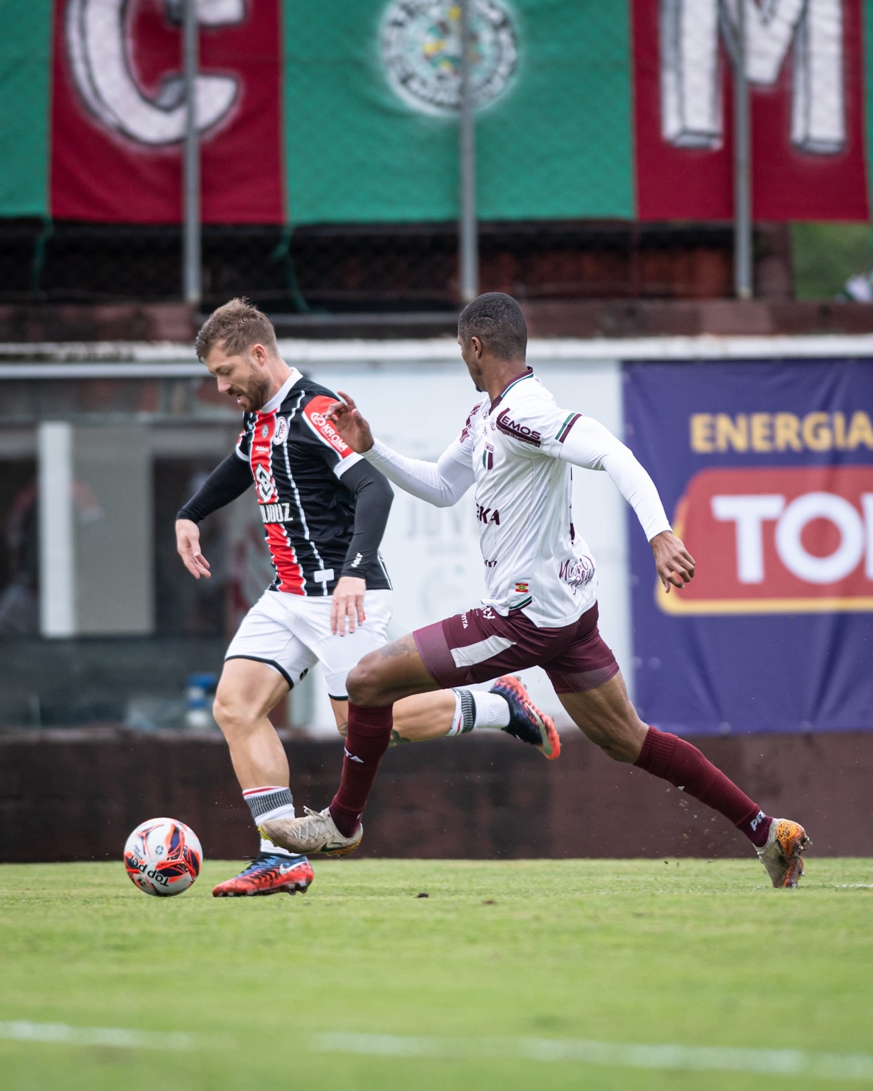 Jogador do Joinville disputa a bola durante partida de futebol.