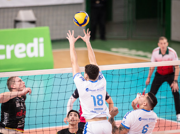 Atletas do Joinville Vôlei em ação junto à rede.