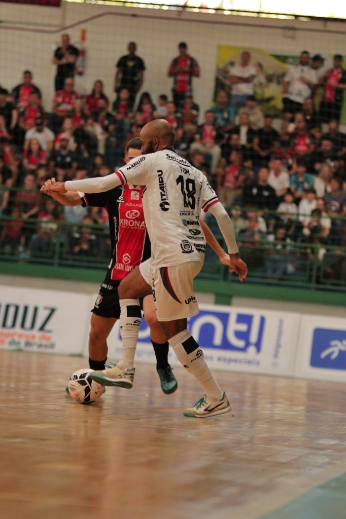 Tom, do Campo Mourão, disputa a bola com atleta do JEC Futsal