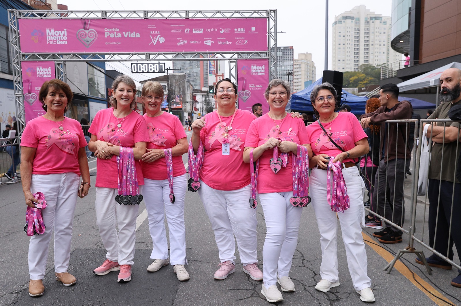 Grupo com medalhas em edição anterior da Corrida pela Vida
