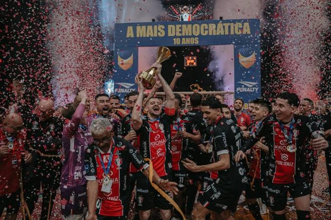 Elenco do JEC Futsal levanta o troféu da Copa do Brasil de 2026 em meio a confetes.