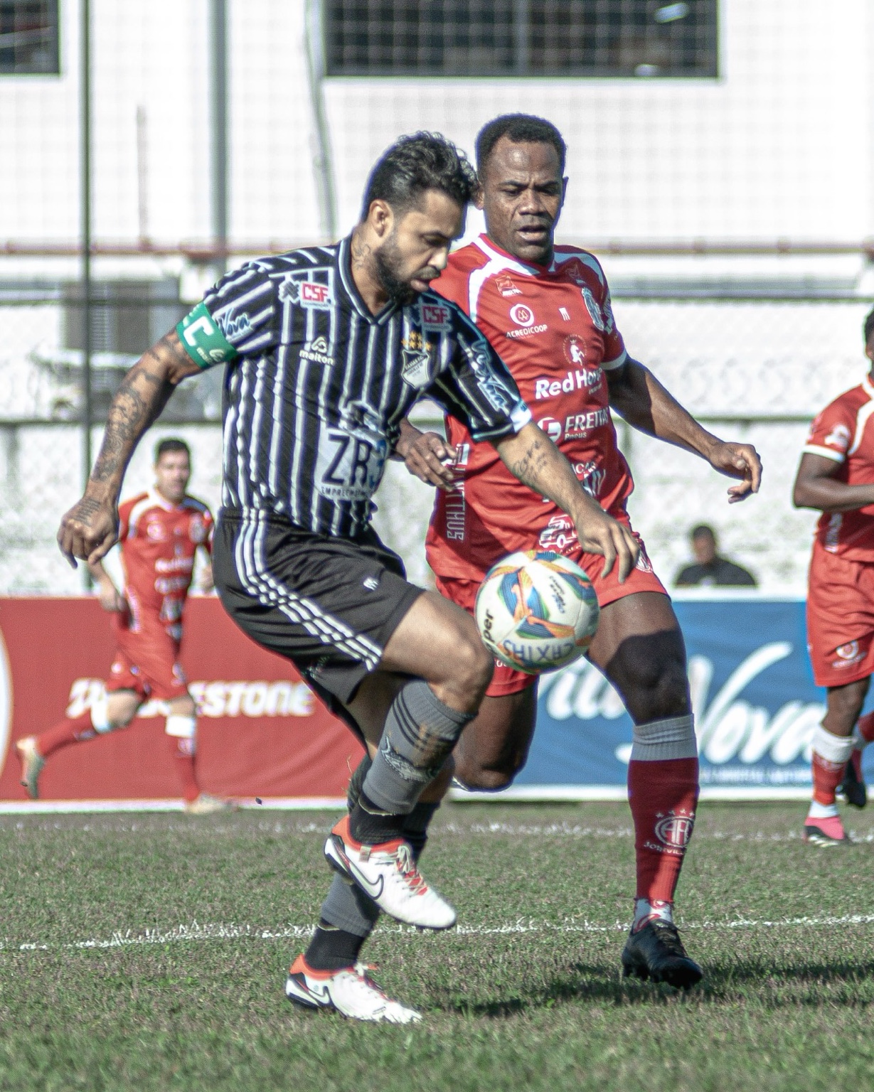 Atletas de Caxias e América disputam a bola no clássico joinvilense.