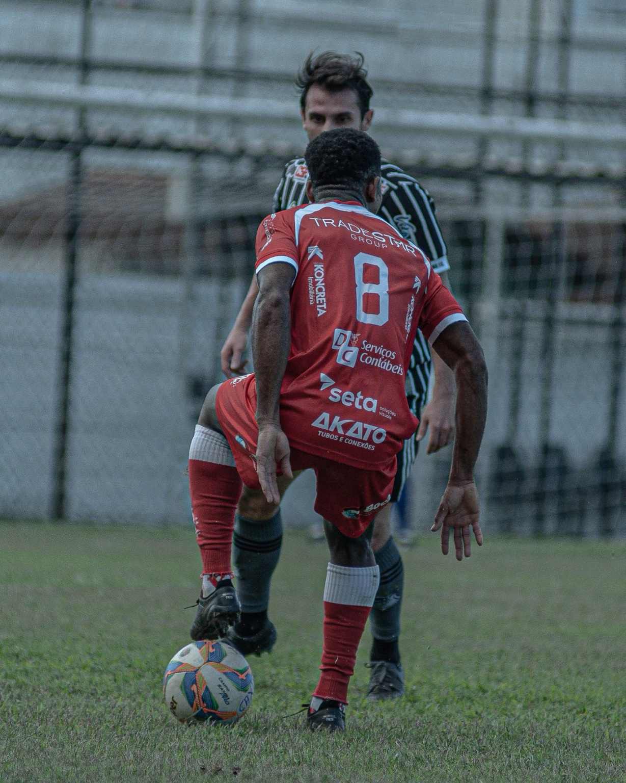 Jogador do América controla a bola diante de adversário do Caxias.