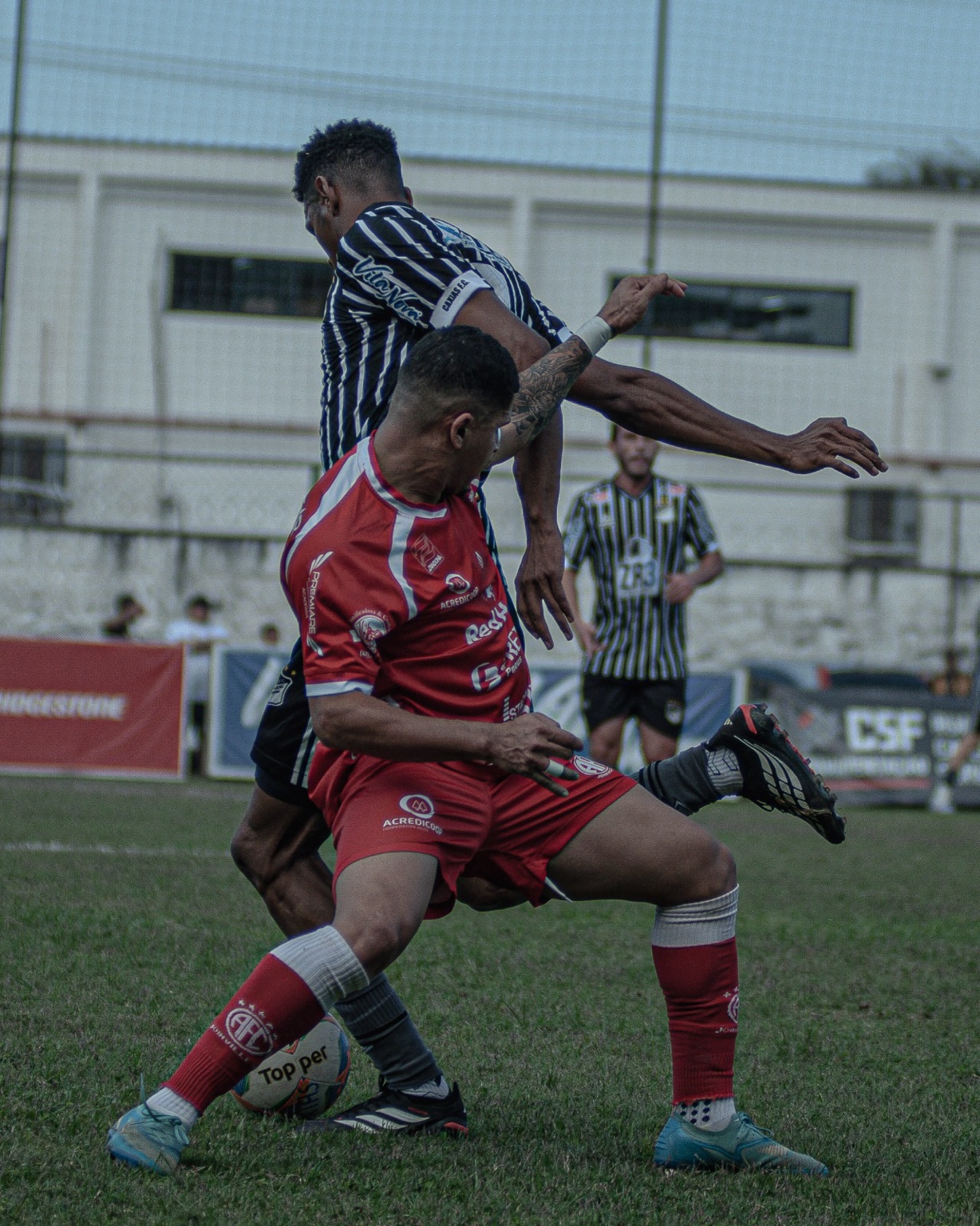 Jogadores de Caxias e América disputam a bola no clássico.