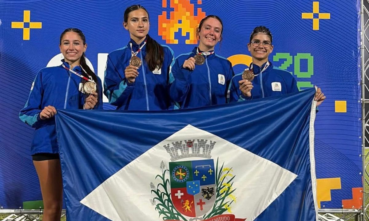 Atletas de Joinville com medalhas e a bandeira da cidade na Olesc